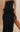 My Sexy Black cow-girl fringe maxi dress hanging on a hanger, showcasing its flowing fabric and western-inspired fringe details.