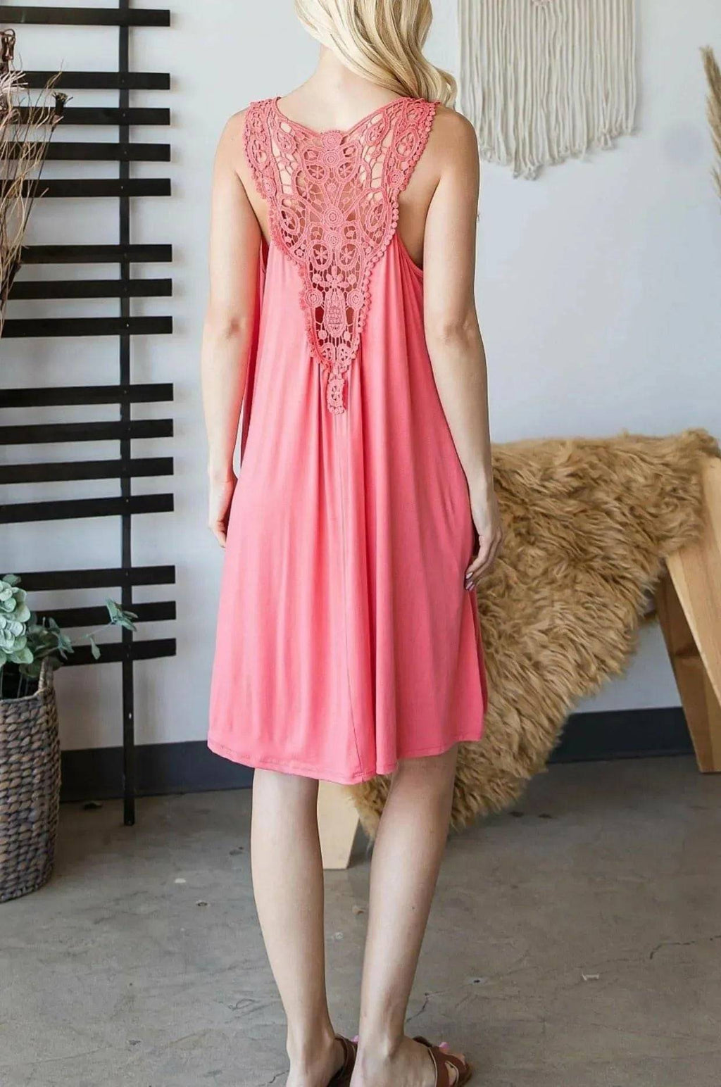 Back of coral Sally Crochet Mini Dress showcasing intricate crochet lace panel and flowy mid-length cut, ideal for summer outings.