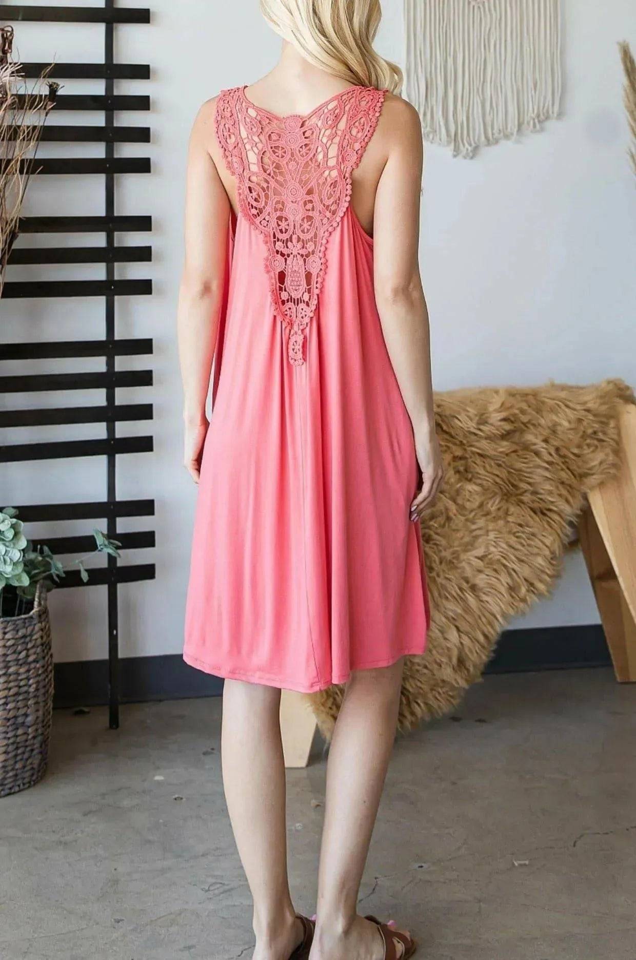 Back of coral Sally Crochet Mini Dress showcasing intricate crochet lace panel and flowy mid-length cut, ideal for summer outings.