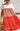 Orange Esley tiered mini dress with ruffled layers, sleeveless design, and a stylish, vibrant look perfect for summer or casual wear.
